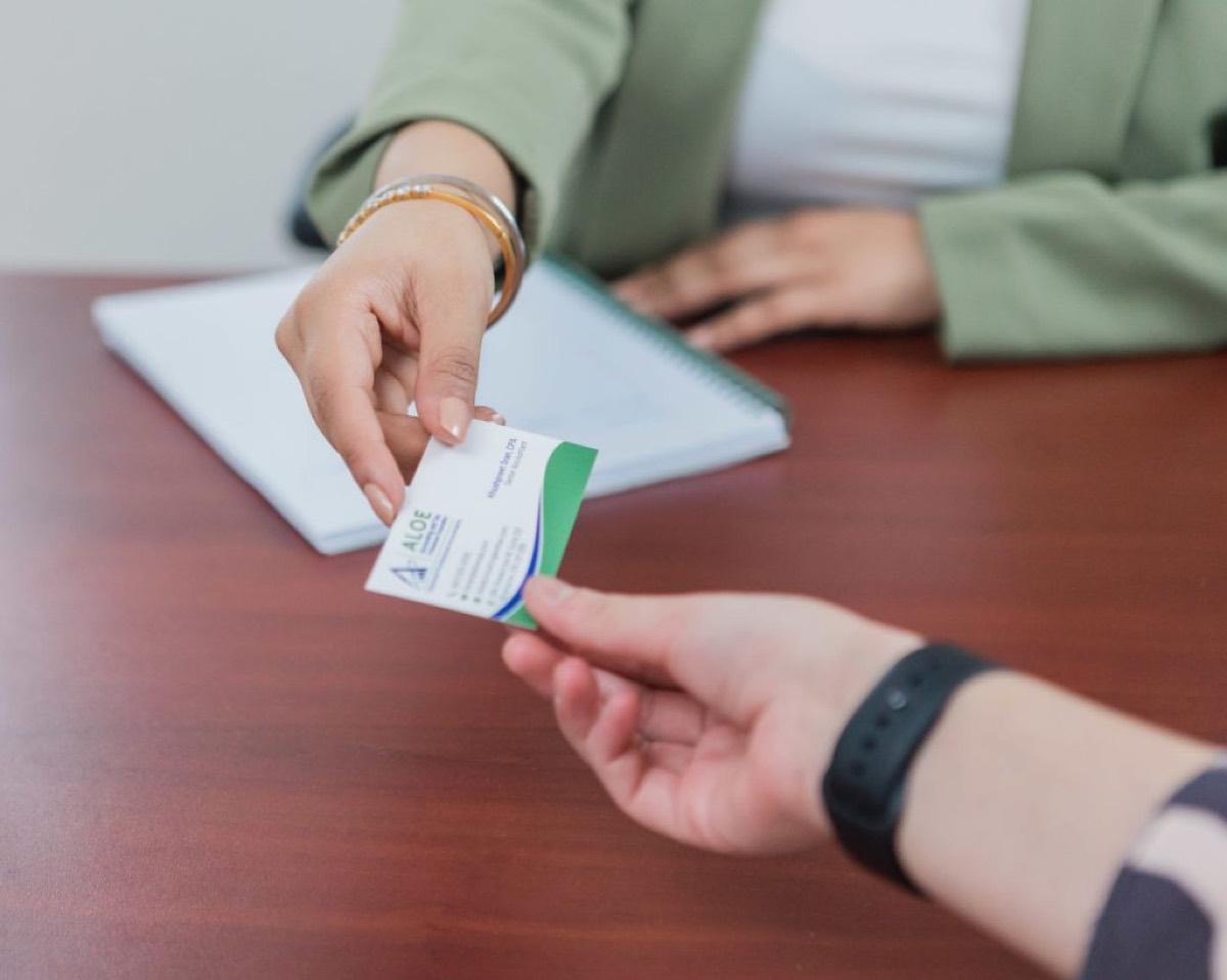 An ALOE Accounting and Tax team member handing a business card to a client