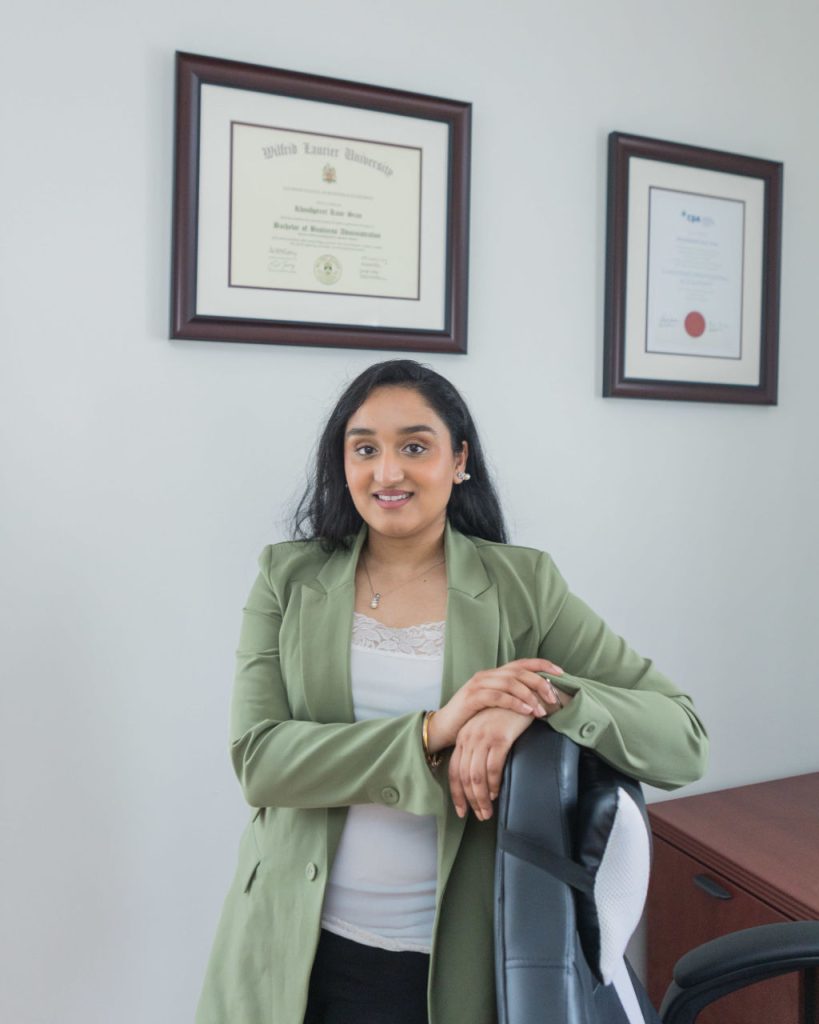 Khushpreet Sran - CPA standing in front of degree
